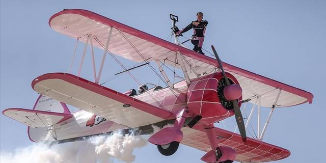 Eşinin kullandığı uçağın kanatlarında yürüyerek gösteri sunuyor