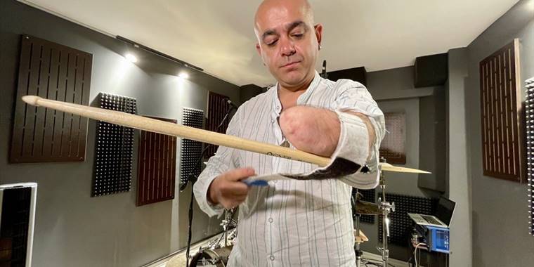 Mehmet Akif öğretmen, ampute koluna sabitlediği bagetle bateri çalıyor